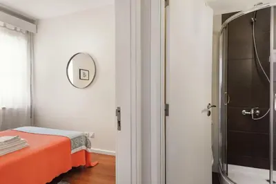a room with a bed and a mirror and a shower at Aida's Haven Penthouse&Parking in Porto