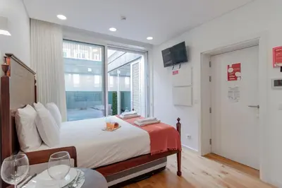 a bedroom with a bed with a large window at Cozy Studio w/ Patio by LovelyStay in Porto