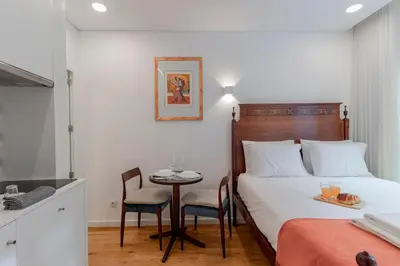 a bedroom with a bed and a table with chairs at Cozy Studio w/ Patio by LovelyStay in Porto