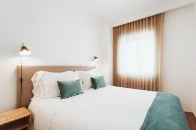 a bedroom with a large white bed and a window at Feel Porto Classic Apartment in Porto