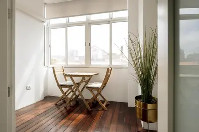 a table and chairs in a room with a window at Feel Porto Classic Apartment in Porto