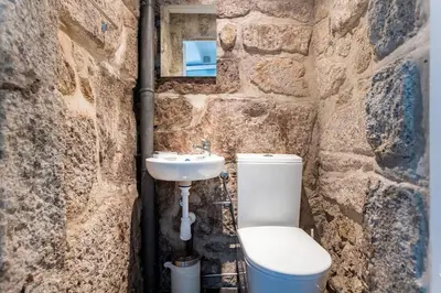 a stone bathroom with a toilet and a sink at Almada Hideaway w/ AC & Private Pool by LovelyStay in Porto