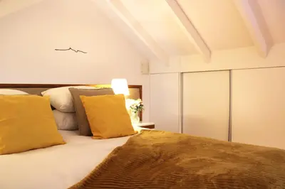 a bedroom with a large bed with yellow pillows at Living Aliados Mezzanine Flat W/ AC in Porto