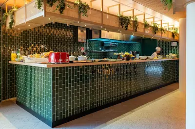 a kitchen with a green tiled counter in a restaurant at The Editory Garden Porto Hotel in Porto