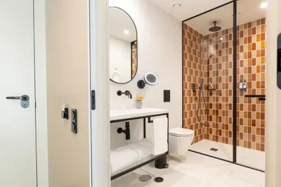 a bathroom with a sink and a toilet and a mirror at The Editory Garden Porto Hotel in Porto