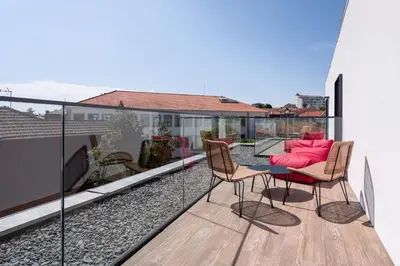 a balcony with a table and chairs on a roof at The Editory Garden Porto Hotel in Porto