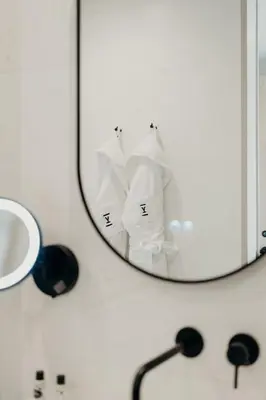 a bathroom mirror with a pile of toilet paper at The Editory Garden Porto Hotel in Porto
