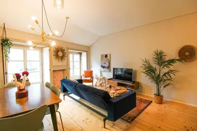 a living room with a blue couch and a table at Virtudes Irresistible Getaway in Porto