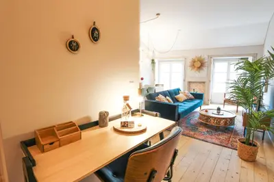 a living room with a table and a blue couch at Virtudes Irresistible Getaway in Porto