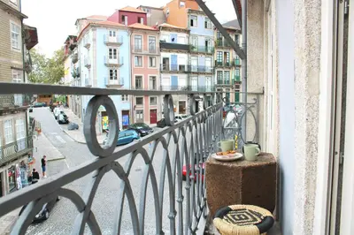 a balcony with a table and two cups of coffee on it at Virtudes Irresistible Getaway in Porto