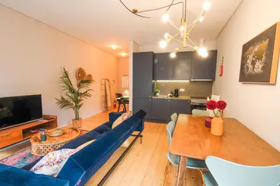 a living room with a blue couch and a table at Virtudes Irresistible Getaway in Porto