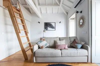 a living room with a couch and a ladder at São Bento Premium Loft - With Air Conditioning in Porto