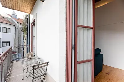 a balcony with a door and a bench on a balcony at Oporto Colorful Flat in Porto