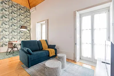 a living room with a blue couch and a table at Oporto Colorful Flat in Porto