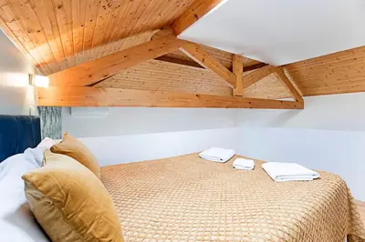 a bed in a room with a wooden ceiling at Oporto Colorful Flat in Porto