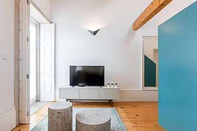a living room with a television and two stools at Oporto Colorful Flat in Porto