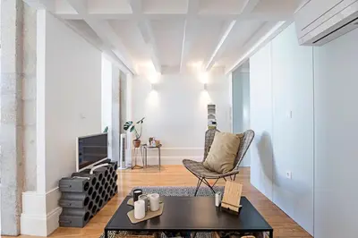 a living room with a chair and a table at O Aleph, irresistible duplex apt. w/AC and balcony in Porto