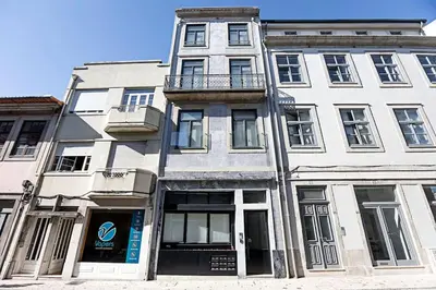 a tall white building on the corner of a street at O Aleph, irresistible duplex apt. w/AC and balcony in Porto