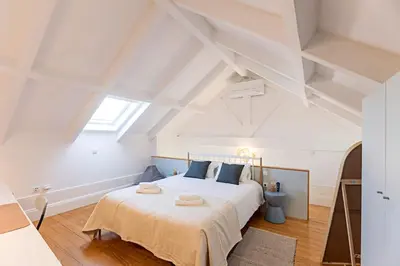 a bedroom with a large white bed with towels on it at O Aleph, irresistible duplex apt. w/AC and balcony in Porto