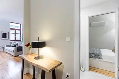 a room with a table with a lamp and a bed at Historical Sunny Marquês - With AC! in Porto
