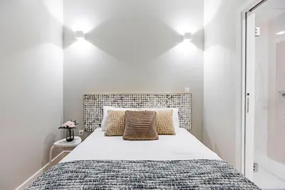 a white bedroom with a large bed with two pillows at Historical Sunny Marquês - With AC! in Porto