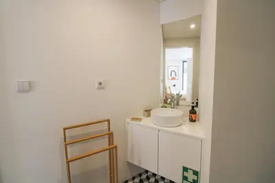 a bathroom with a white sink and a mirror at Porto Trindade Triplex in Porto