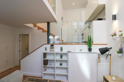a living room with a staircase and white walls at Porto Trindade Triplex in Porto