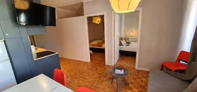 a living room with a table and a room with a bed at Molecular Apartment in Porto