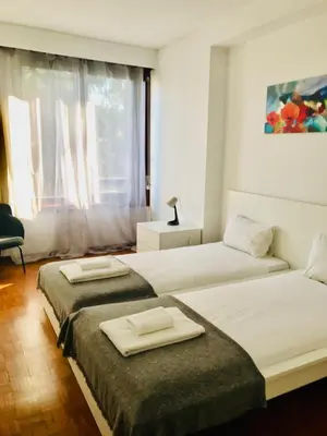 two beds in a room with a window at Bairro das arts in Porto
