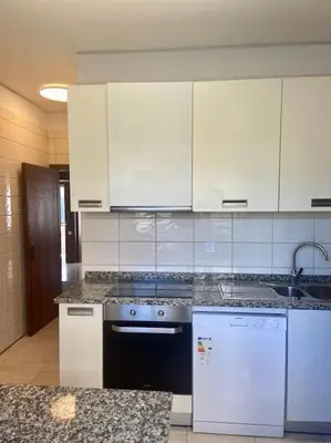 a kitchen with white cabinets and a stove top oven at Bairro das arts in Porto