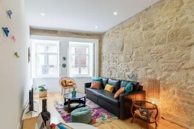 a living room with a couch and a brick wall at Riverside Cozy Studio by LovelyStay in Porto