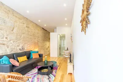 a living room with a couch and a stone wall at Riverside Cozy Studio by LovelyStay in Porto