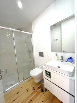 a bathroom with a toilet and a sink and a shower at Caldeireiros Lovely Suite by Porto City Hosts in Porto