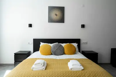 a bedroom with a yellow bed with two towels on it at Almada Downtown 202 in Porto
