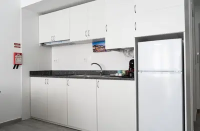 a white kitchen with a sink and a refrigerator at Almada Downtown 202 in Porto