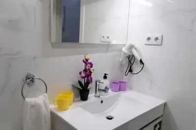 a white bathroom with a sink and a mirror at Almada Downtown 202 in Porto