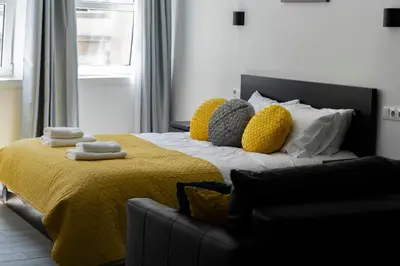 a bedroom with a bed with a yellow blanket and pillows at Almada Downtown 202 in Porto