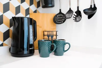 a coffee pot and three cups on a counter at GuestReady - Studio in Porto in Porto