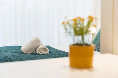 a towel and a vase of flowers on a table at GuestReady - Studio in Porto in Porto