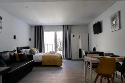 a living room with a couch and a bed and a table at Almada Downtown 203 in Porto
