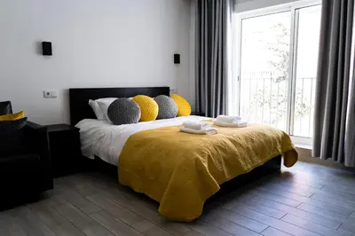 a bedroom with a bed with a yellow blanket and a window at Almada Downtown 203 in Porto