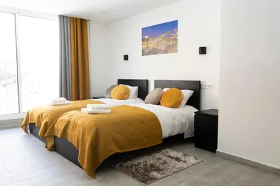 a bedroom with a king sized bed with yellow sheets at Almada Downtown 204 in Porto