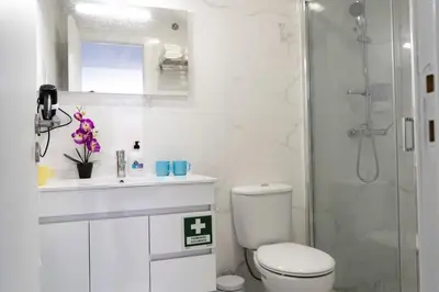 a white bathroom with a toilet and a shower at Almada Downtown 303 in Porto