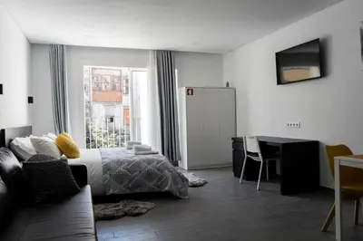 a bedroom with a bed and a table and a desk at Almada Downtown 303 in Porto
