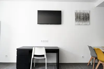 a black desk with chairs and a tv on a wall at Almada Downtown 303 in Porto