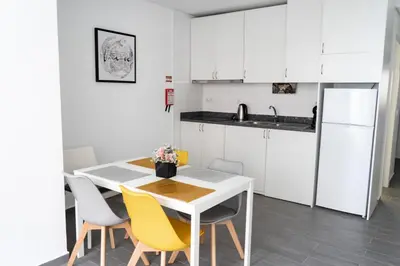 a kitchen with a white table and yellow chairs at Almada Downtown 304 in Porto