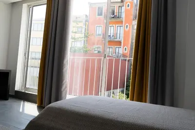 a bedroom with a bed and a large window at Almada Downtown 304 in Porto