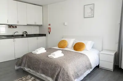 a white bedroom with a bed with towels on it at Almada Downtown 401 in Porto