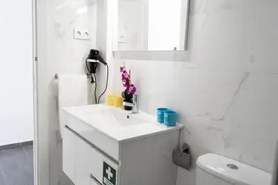a white bathroom with a sink and a toilet at Almada Downtown 401 in Porto