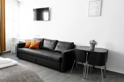 a living room with a black couch and a table at Almada Downtown 401 in Porto